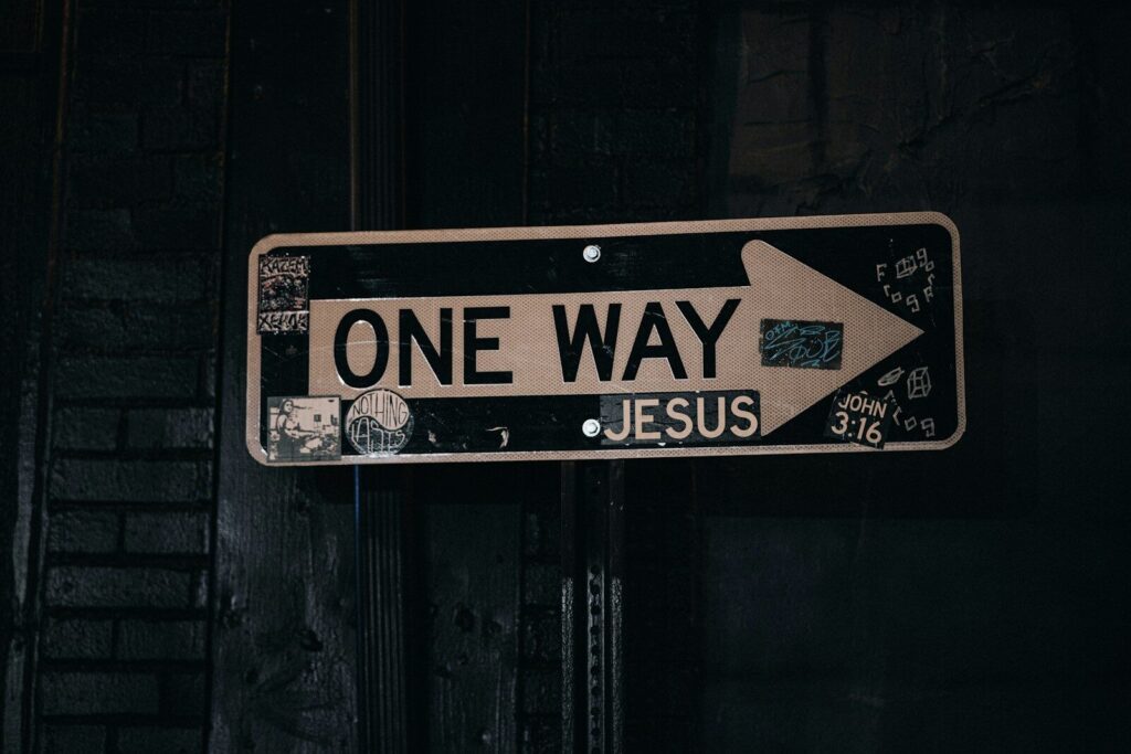 a one way sign hanging from the side of a building