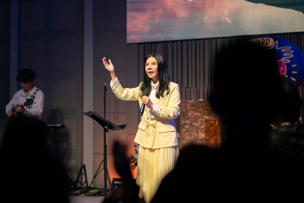 A woman sings on stage with a band.